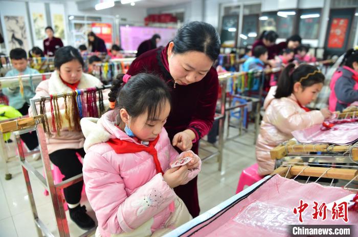 江西省級(jí)非遺豫章繡傳承人手把手指導(dǎo)小學(xué)生繡制2022年北京冬奧會(huì)吉祥物“冰墩墩”形象?！∮髟屏?攝