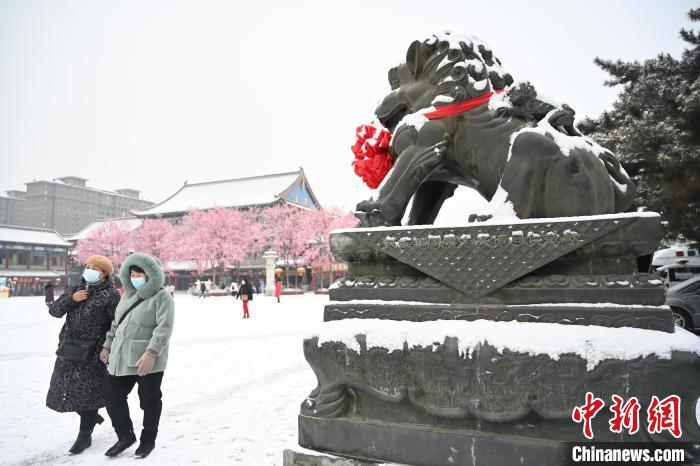 2月13日，民眾在呼和浩特市大召?gòu)V場(chǎng)雪中漫步?！⑽娜A 攝