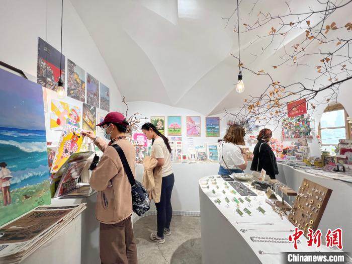 圖為藝術(shù)品商店內(nèi)，顧客挑選插畫作品。　鐘旖 攝