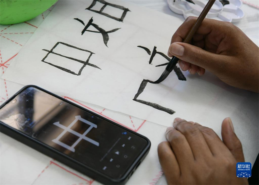 4月18日，肯尼亞學(xué)生在內(nèi)羅畢大學(xué)孔子學(xué)院舉辦的活動上寫毛筆字?？夏醽唭?nèi)羅畢大學(xué)孔子學(xué)院18日舉辦“中文，增進(jìn)文明對話”主題活動，慶祝即將到來的第14個聯(lián)合國中文日?？夏醽唽W(xué)生參與互動，進(jìn)行書法、剪紙、唱中文歌等活動。新華社記者 韓旭 攝