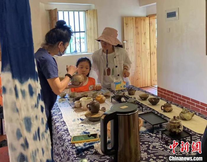 圖為：游客正在咨詢臺灣柴燒作品?！∪~秋云 攝