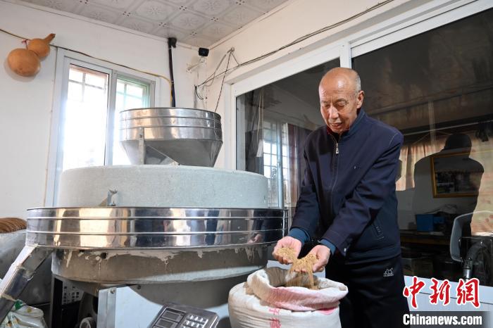 李家莊村民谷文朝重拾父輩的手藝，做起石磨面粉的營(yíng)生?！〉杂鸺?攝