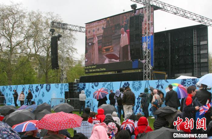 當(dāng)?shù)貢r(shí)間5月6日，英國(guó)國(guó)王查爾斯三世的加冕儀式舉行。民眾雨中觀看儀式。　歐陽(yáng)開宇 攝