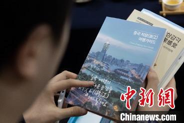 參展觀眾閱讀浙江文旅手冊(cè)?！《≌裾?攝