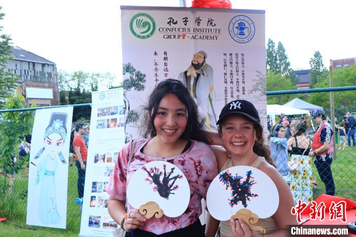 孩子們展示自己的吹墨畫團扇作品?！◆斻肟鬃訉W(xué)院供圖