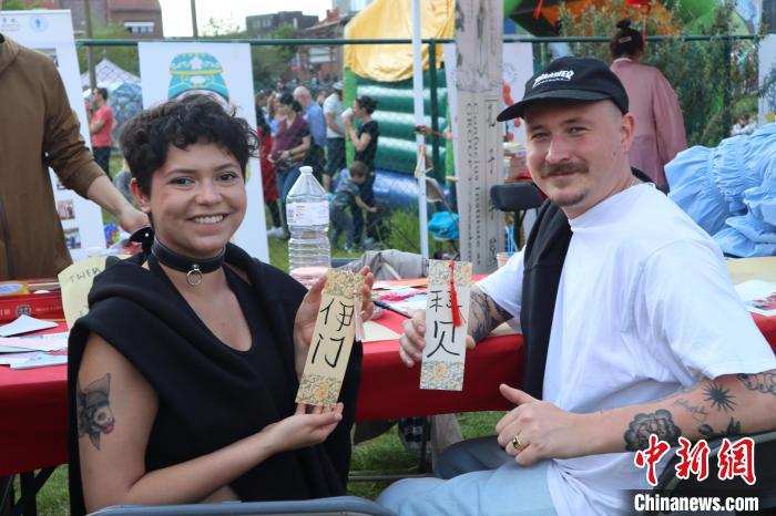 當(dāng)?shù)孛癖娫跐h字體驗工作坊展示自己手寫的中文名書簽?！◆斻肟鬃訉W(xué)院供圖