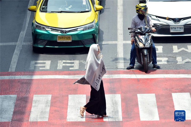 5月17日，行人在泰國曼谷街頭用圍巾遮陽。新華社發(fā)（拉亨攝）