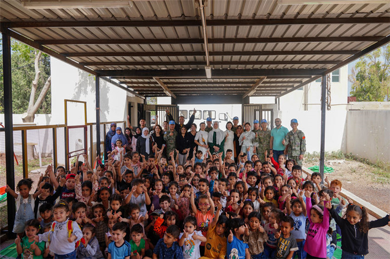 當?shù)貢r間5月30日，黎巴嫩南部庫雷拉公立小學，“六一”國際兒童節(jié)前夕，中國第21批赴黎維和多功能工兵分隊官兵看望慰問學校師生，并開展文化交流活動，圖為我維和官兵同師生合影。李竹林攝