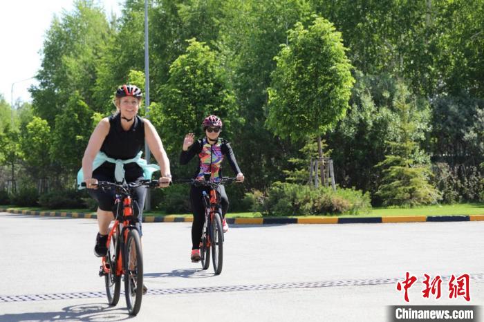 亞信副秘書長(zhǎng)遲方(右一)與聯(lián)合國(guó)駐哈協(xié)調(diào)員在騎行活動(dòng)中?！喰琶貢幑﹫D