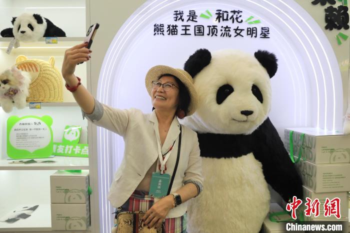 美國華視總裁楊蓮花與大熊貓文創(chuàng)產(chǎn)品合影。　王磊 攝