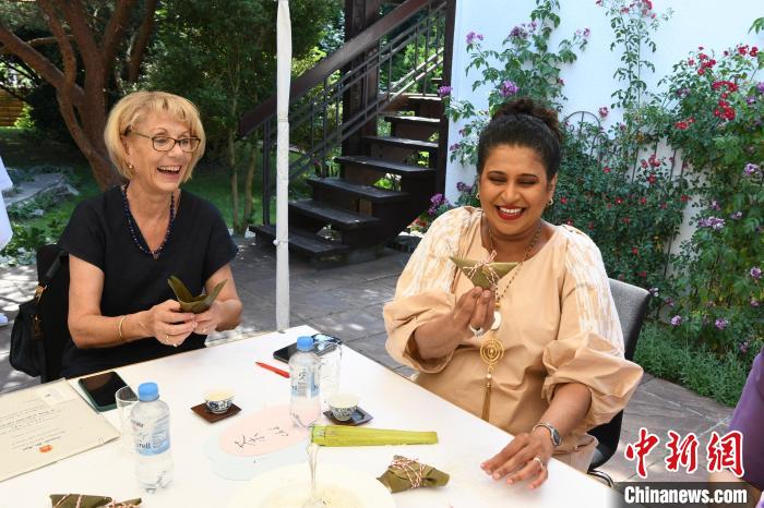 圖為嘉賓展示包粽子成果?！“亓种袊幕行墓﹫D。