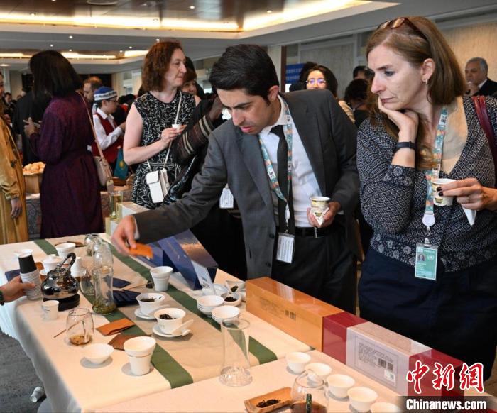 現(xiàn)場觀眾觀看中國展臺茶藝表演、了解茶文化。　靖樹 攝