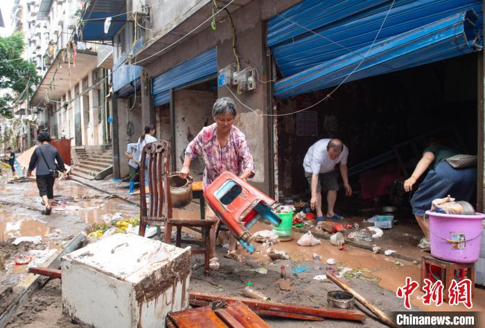 7月4日，萬州區(qū)五橋街道，洪水退去后，居民搶救生活物資?！∪矫宪?攝