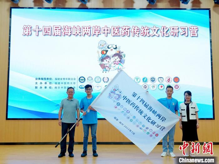 共青團(tuán)福建省委副書記吳雪(右一)、福建中醫(yī)藥大學(xué)黨委副書記林羽(左一)為兩岸學(xué)生代表頒授營(yíng)旗?！≡S燁婷 攝