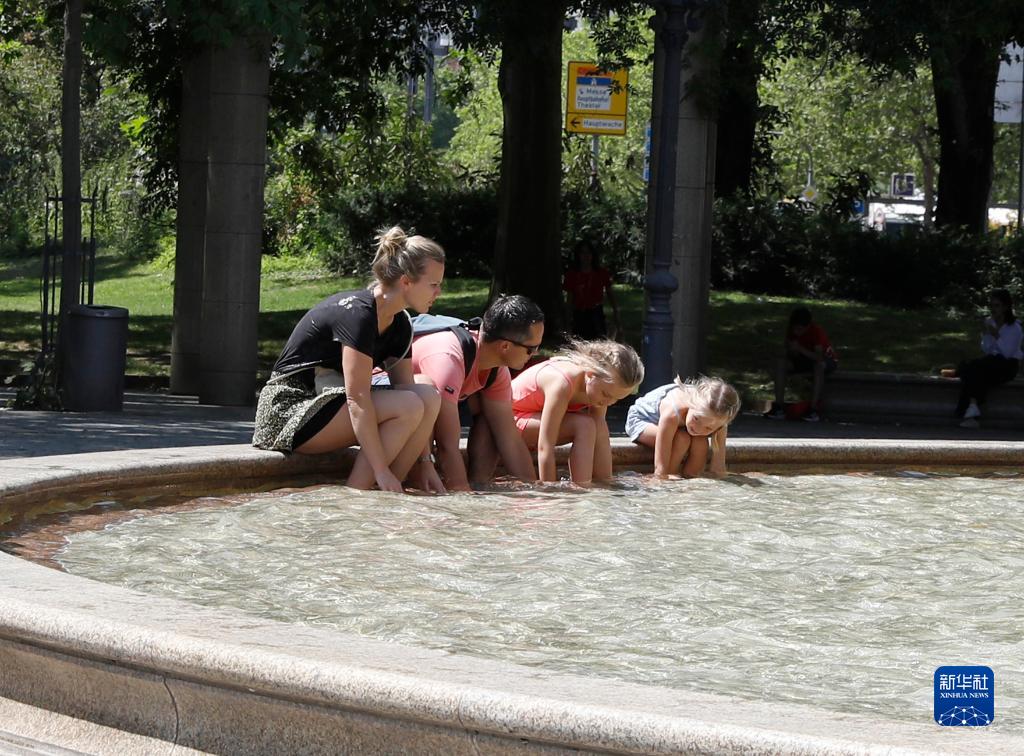 7月8日，人們在德國法蘭克福的一處噴泉玩水。近日，德國法蘭克福逐漸迎來暑熱天氣。新華社記者 張帆 攝