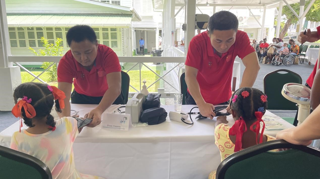 醫(yī)療隊(duì)員為福利院兒童進(jìn)行檢查。第18期援圭亞那醫(yī)療隊(duì)供圖