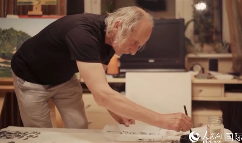 伊戈?duì)枴げ紶枛|諾夫在畫作上題詞。人民網(wǎng)記者 馬天翼攝