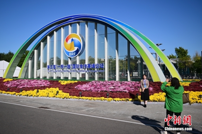 10月15日，北京，工作人員在國家會(huì)議中心外的第三屆“一帶一路”國際合作高峰論壇景觀布置前拍照留念。當(dāng)日，位于國家會(huì)議中心的第三屆“一帶一路”國際合作高峰論壇新聞中心啟動(dòng)試運(yùn)行。據(jù)悉，第三屆“一帶一路”國際合作高峰論壇將于10月17日至18日在北京舉行。<a target='_blank' href='/'><p  align=