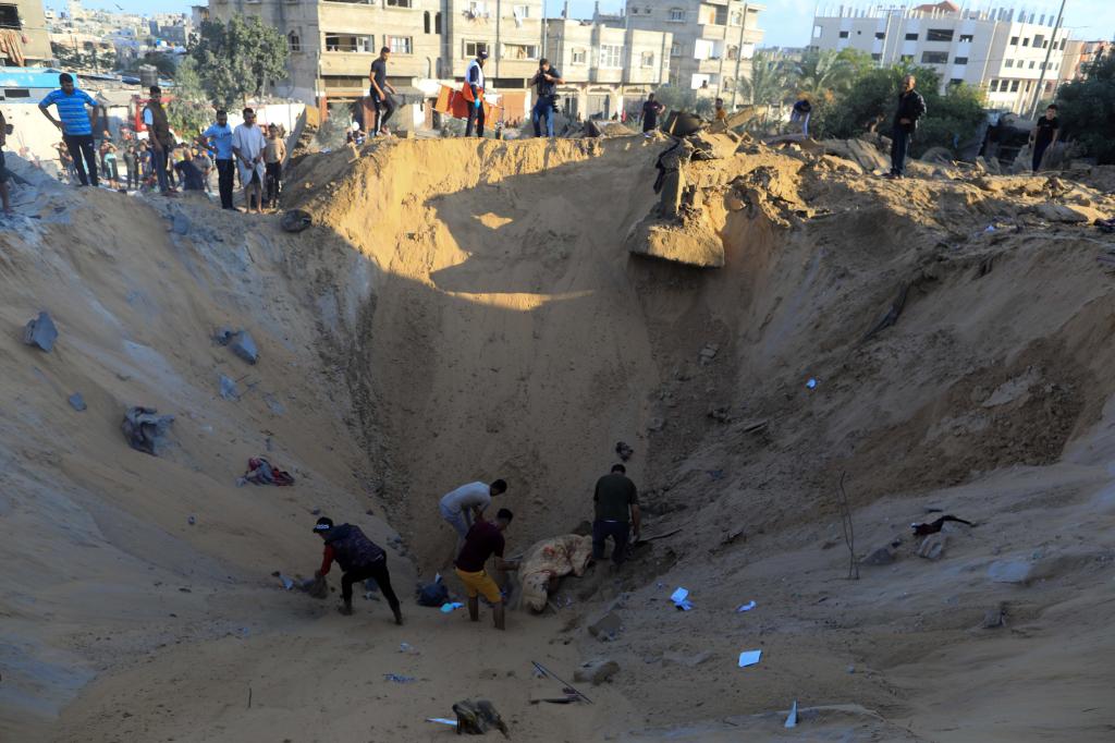 10月16日，在加沙地帶南部城市汗尤尼斯，人們?cè)谠庖陨幸u擊后的建筑廢墟中救援傷者。 新華社發(fā)（亞西爾·庫(kù)迪 攝）