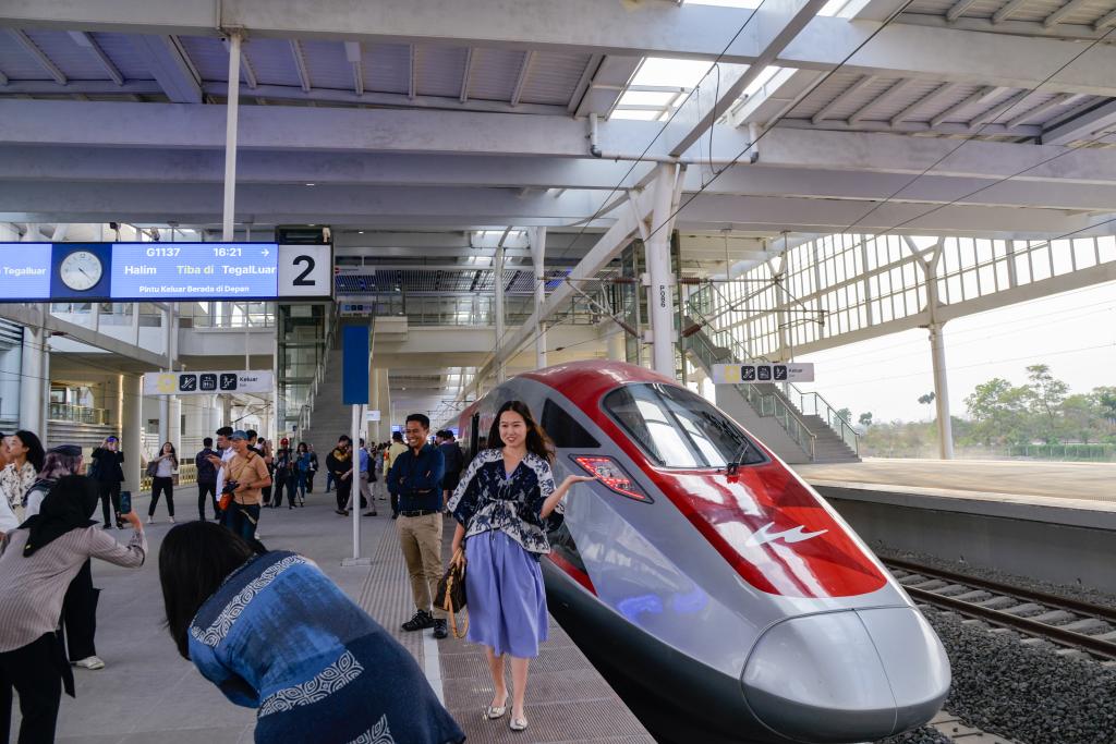10月17日，在印度尼西亞萬隆德卡魯爾站，乘客在站臺上和雅萬高鐵高速動車組列車合影。