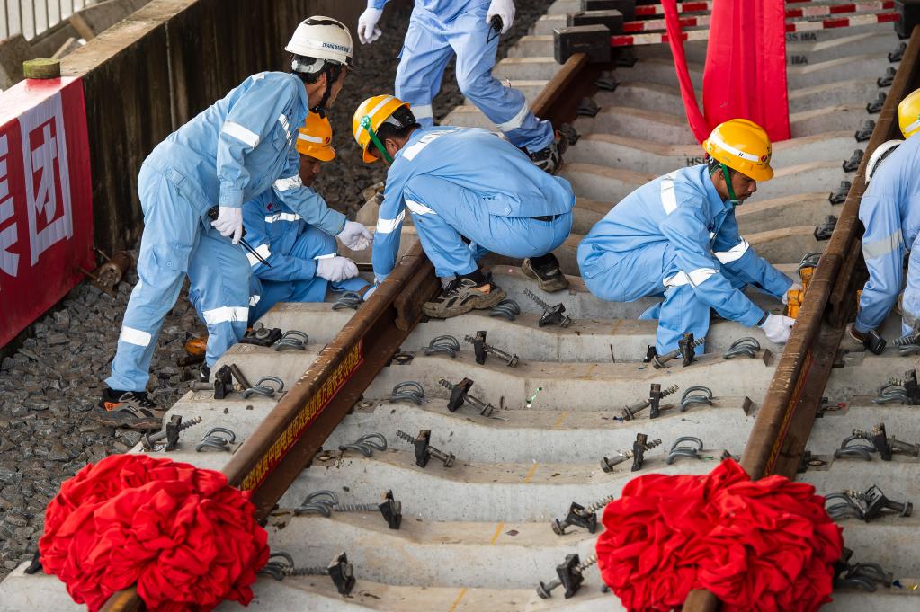 3月31日，在印度尼西亞雅加達雅萬高鐵哈利姆車站，工人鋪設(shè)雅萬高鐵全線最后一根鋼軌。