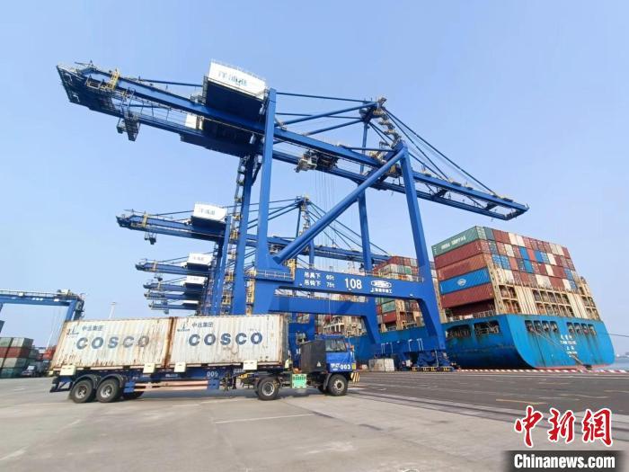 圖為海南洋浦國際集裝箱碼頭，卡車將集裝箱從后方堆場運往碼頭裝卸區(qū)?！堅潞?攝