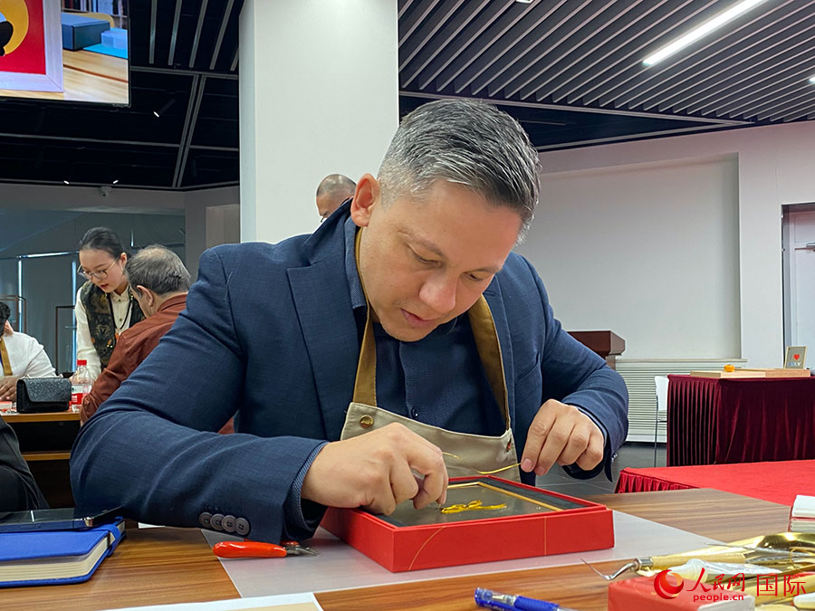 2023“一帶一路”媒體合作論壇聯(lián)合采訪團團員，親身體驗景泰藍工藝。人民網(wǎng)記者 于洋攝