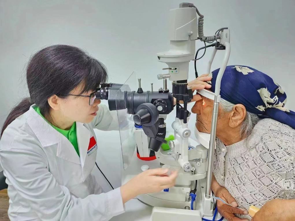 北京大學(xué)人民醫(yī)院眼科醫(yī)生鮑永珍正在為中亞白內(nèi)障患者進(jìn)行眼部檢查。（北京大學(xué)人民醫(yī)院供圖）