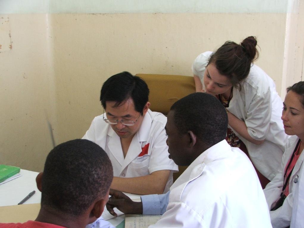 2011年7月22日，在坦桑尼亞桑給巴爾納茲莫加醫(yī)院外科門(mén)診，中國(guó)第24批援桑給巴爾醫(yī)療隊(duì)隊(duì)長(zhǎng)盧建林為當(dāng)?shù)鼗颊咴\治并帶教實(shí)習(xí)生。新華社發(fā)（國(guó)家衛(wèi)生健康委供圖）