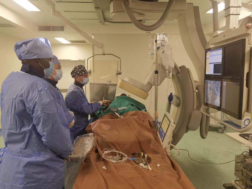中國(guó)第29批援幾內(nèi)亞醫(yī)療隊(duì)隊(duì)員、首都醫(yī)科大學(xué)附屬北京天壇醫(yī)院心內(nèi)科副主任醫(yī)師王汝朋（右一）正在給患者做手術(shù)。（北京天壇醫(yī)院供圖）