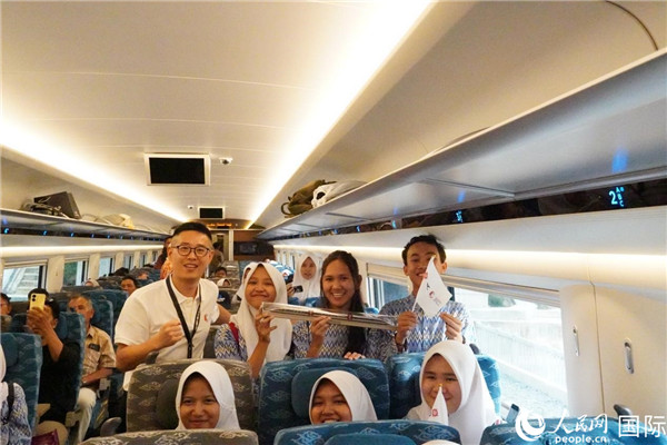 第一次乘坐雅萬高鐵動車組的學(xué)生們與動車組模型合影。人民網(wǎng)記者曹師韻攝