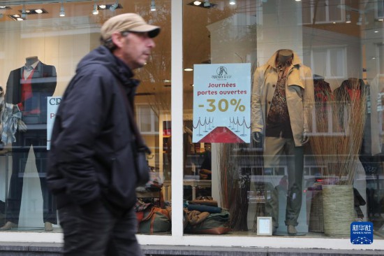   10月31日，一名男子從比利時布魯塞爾一家貼有打折信息的店鋪前走過。新華社記者 趙丁喆 攝