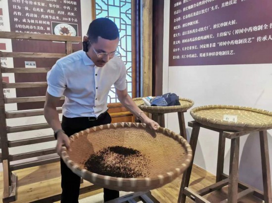 2023“一帶一路”媒體合作論壇聯(lián)合采訪團(tuán)團(tuán)員在非遺文化展示館體驗(yàn)中藥炮制技藝。（本報(bào)記者 黃超攝）