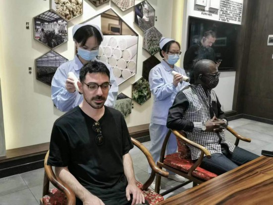 2023“一帶一路”媒體合作論壇聯(lián)合采訪團(tuán)團(tuán)員在九牛草展示館體驗(yàn)艾灸。（本報(bào)記者 黃超攝）