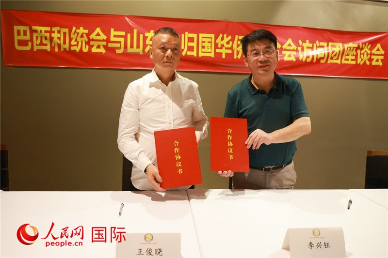 中國僑聯(lián)副主席、山東省僑聯(lián)主席李興鈺（右）與巴西和統(tǒng)會會長王俊曉簽署合作協(xié)議書。人民網(wǎng)記者 陳海琪攝