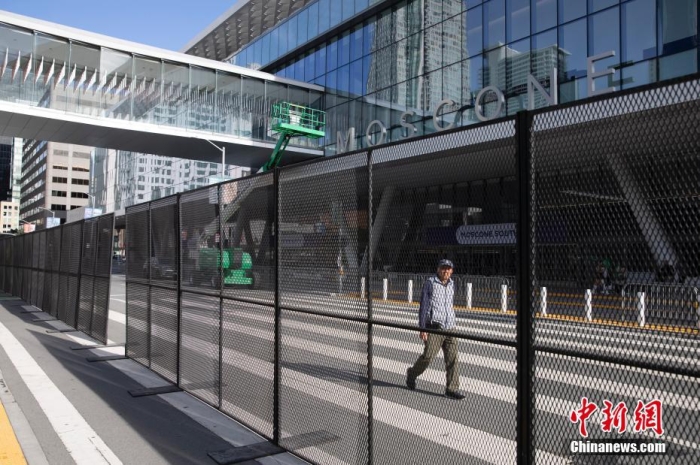 當(dāng)?shù)貢r(shí)間11月10日，一名行人從美國(guó)舊金山莫斯康中心周圍的金屬圍欄旁經(jīng)過。隨著亞太經(jīng)合組織(APEC)第三十次領(lǐng)導(dǎo)人非正式會(huì)議臨近，作為會(huì)議場(chǎng)地的莫斯康中心附近出現(xiàn)金屬圍欄，執(zhí)勤警察也大幅增加。<a target='_blank' href='/'><p  align=