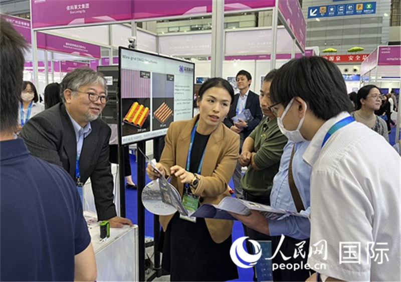 工作人員向參觀者介紹超級噴墨技術(shù)。（人民網(wǎng)記者 陳思攝）