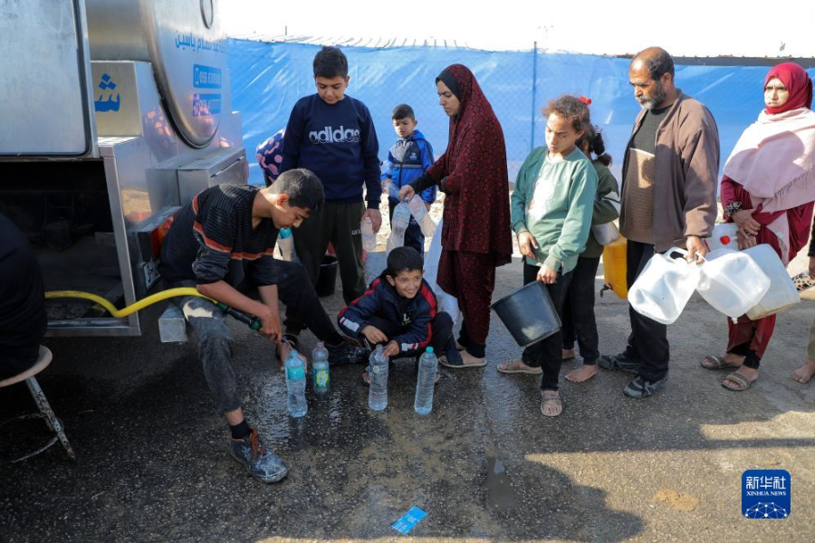 12月8日，在加沙地帶南部城市拉法一處臨時(shí)營地內(nèi)，人們排隊(duì)打水。新華社發(fā)（里澤克·阿卜杜勒賈瓦德 攝）