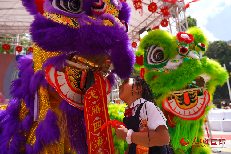 小朋友與舞獅表演者互動。人民網(wǎng)記者 黃煒鑫攝