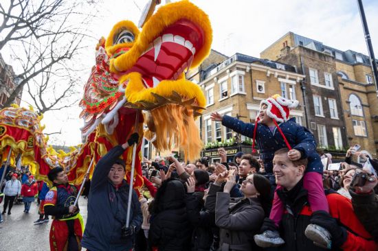 2月11日，人們?cè)谟?guó)倫敦的新春巡游活動(dòng)中觀看舞龍表演。新華社發(fā)（史蒂芬·程攝）