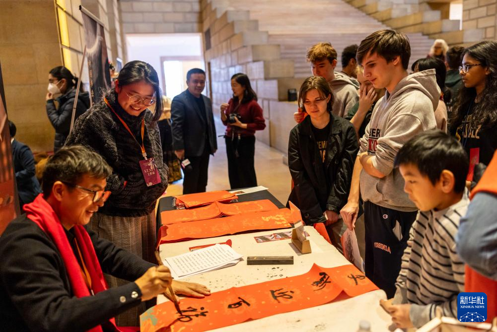 2月11日，書法家在美國費城藝術(shù)博物館舉行的龍年迎新春活動上為參觀者書寫對聯(lián)。新華社發(fā)（周煥新攝）