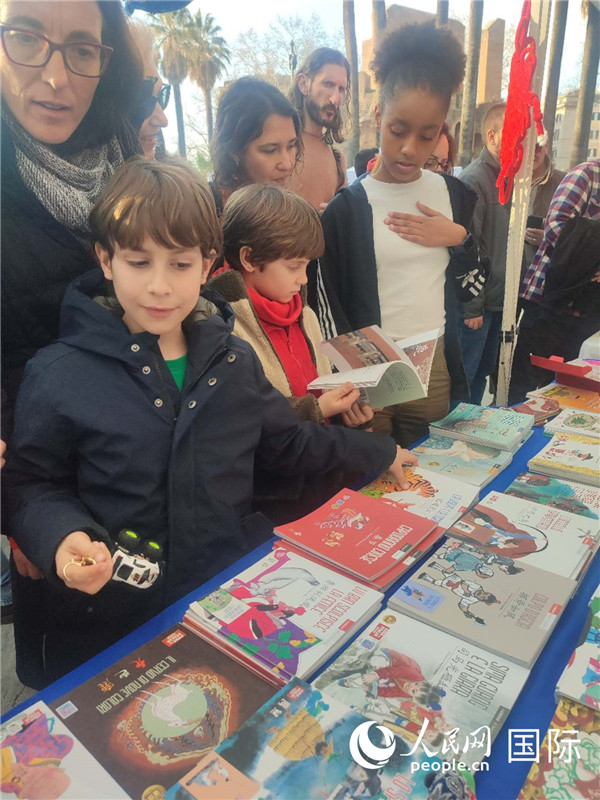 印刷精美的中國(guó)傳統(tǒng)文化叢書吸引了小游客的注意。人民網(wǎng)記者鄭彬攝