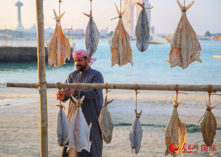    手工藝者展示如何晾曬魚干。人民網(wǎng) 塔里克·易卜拉欣攝