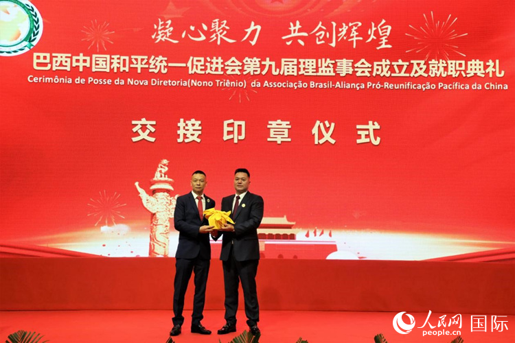 就職典禮中，巴西和統(tǒng)會第七屆和第八屆會長王俊曉與新任會長張小春交接印章。人民網記者 時元皓攝