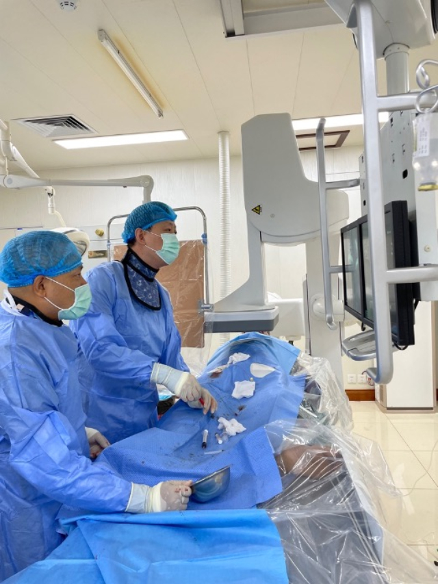 李凱教授（右）和劉海濤教授（左）為患者行TACE手術(shù)。中國(guó)駐老撾大使館供圖