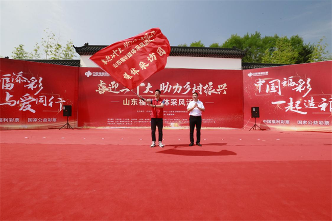 為媒體采風團授旗。 山東省福彩供圖