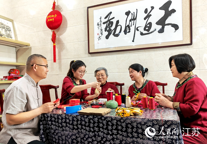 王秀英老人指導(dǎo)孫女制作香包。人民網(wǎng) 閆峰攝