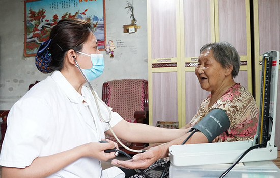 護(hù)理團(tuán)隊(duì)醫(yī)生為老人測(cè)量血壓。 陳佳兵攝