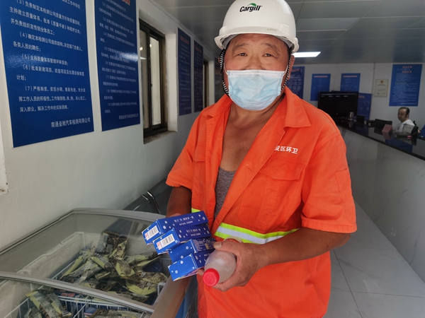 1環(huán)衛(wèi)工倪建宏小憩后，為還同事帶去冷飲。人民網(wǎng)記者王繼亮攝