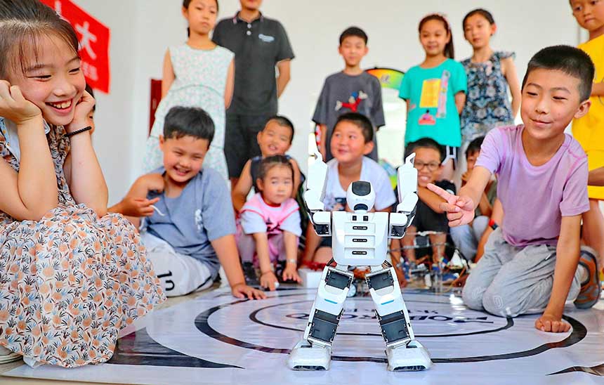 2022年7月19日，河北省秦皇島市海港區(qū)白塔嶺街道秦皇半島第二社區(qū)內(nèi)，小朋友正在觀看“機(jī)器人跳舞”。 曹建雄攝